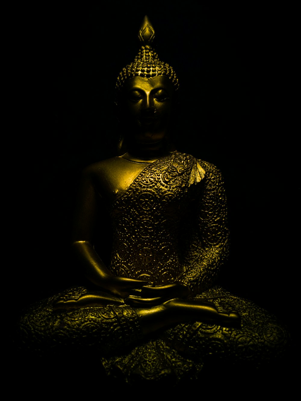 gold buddha statue on black textile