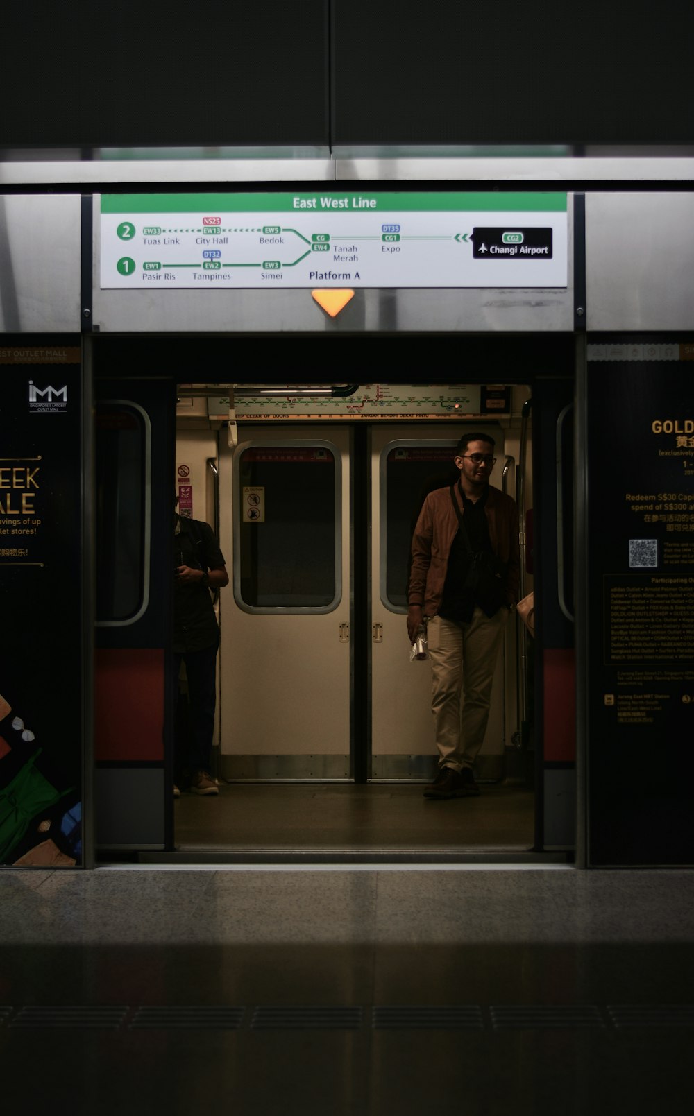 man in black jacket standing in train