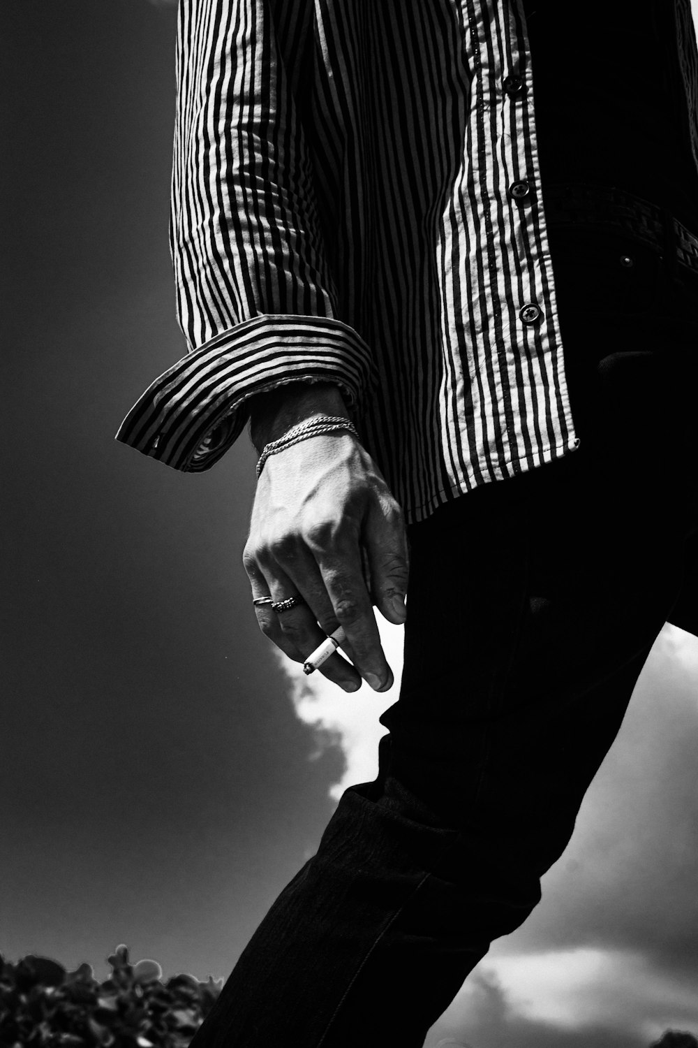 grayscale photo of man in striped shirt and black pants