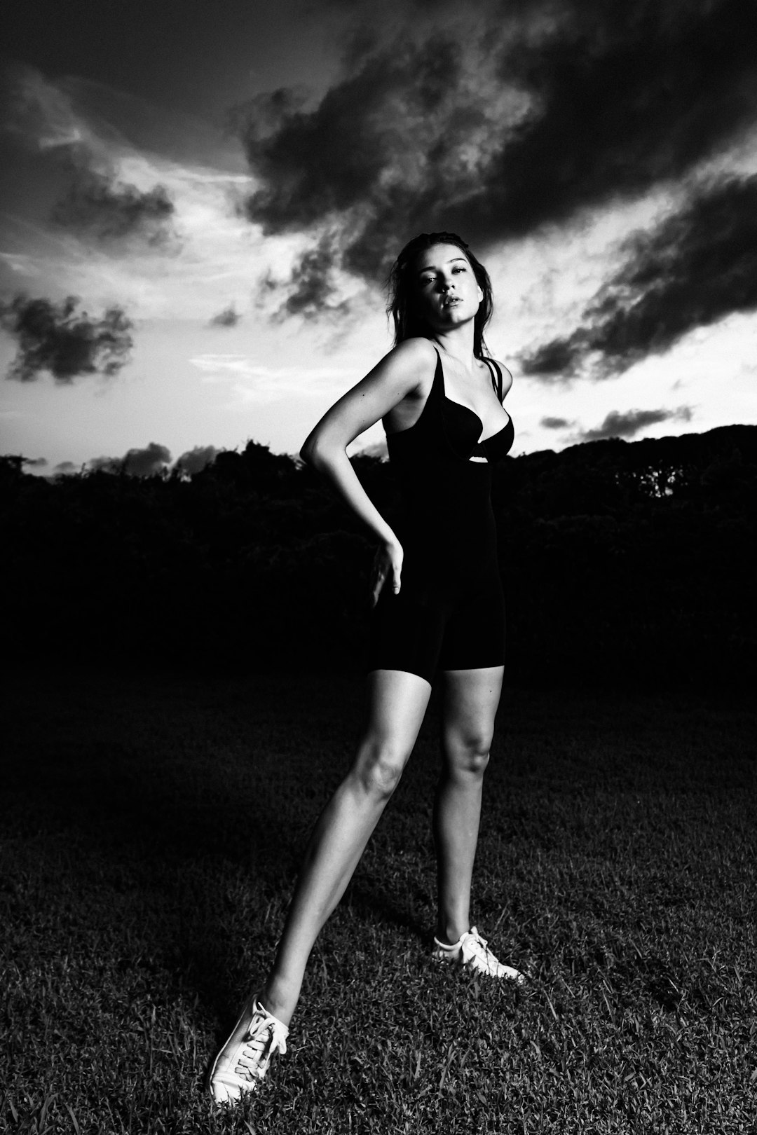 woman in black tank top and black shorts standing on grass field