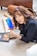 woman in black blazer holding blue smartphone