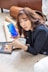 woman in black blazer holding blue smartphone
