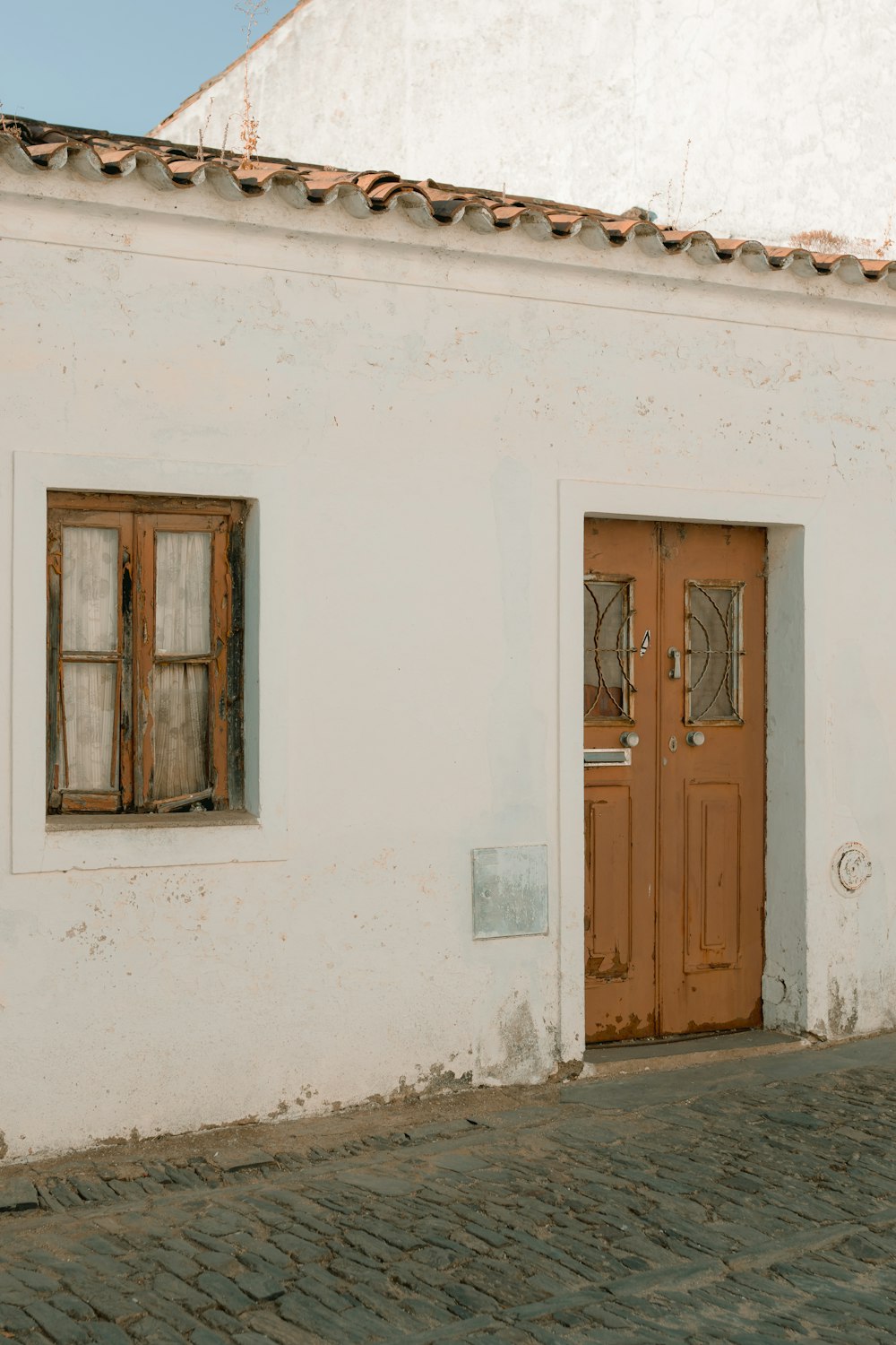 brown wooden door on white concrete wall