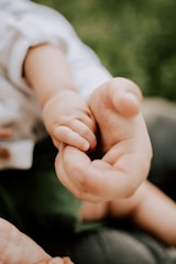 person holding babys hand