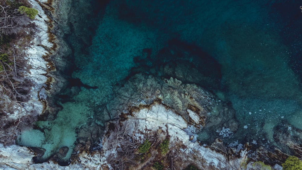 brown and white rock formation on body of water