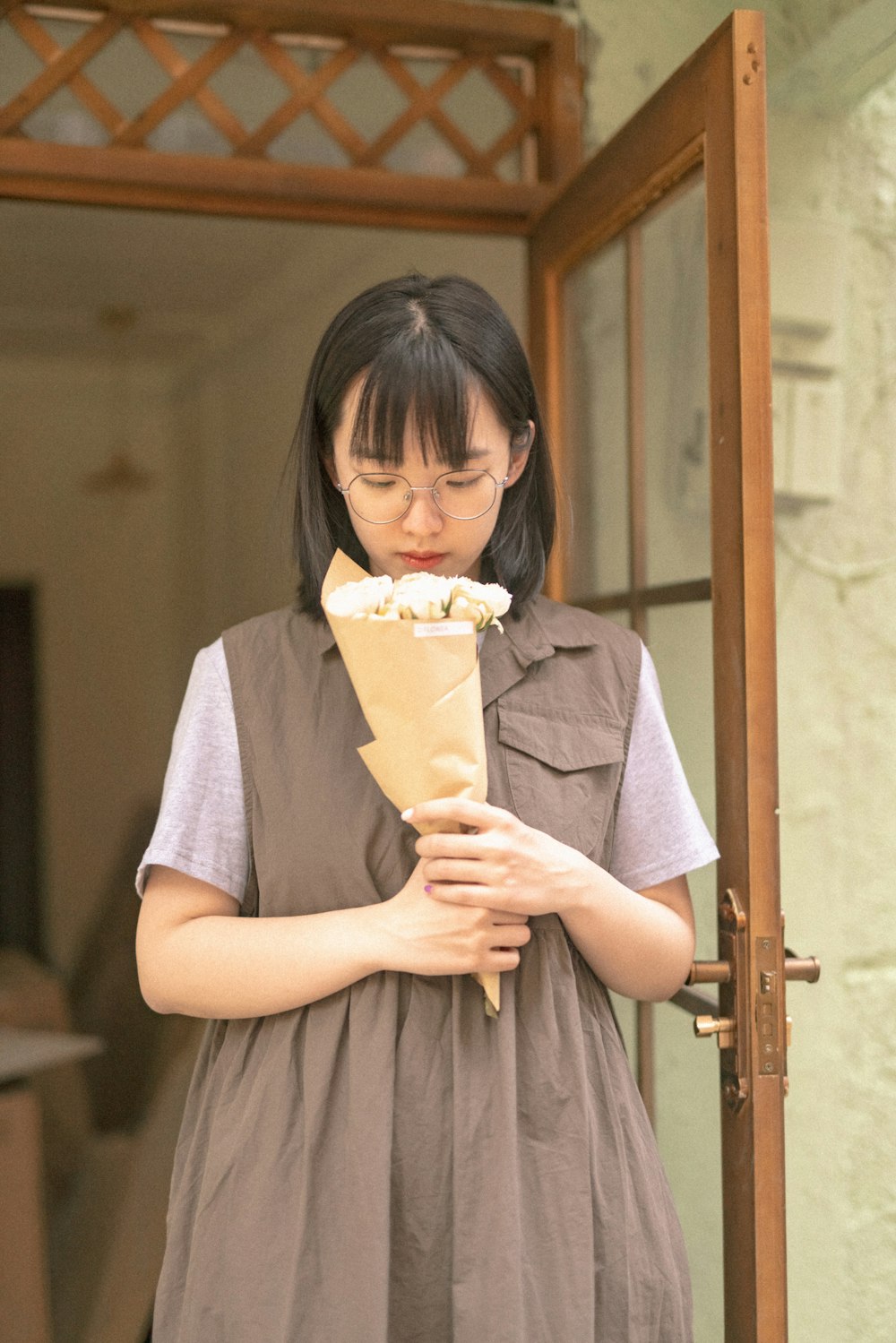 woman in gray dress holding brown cone