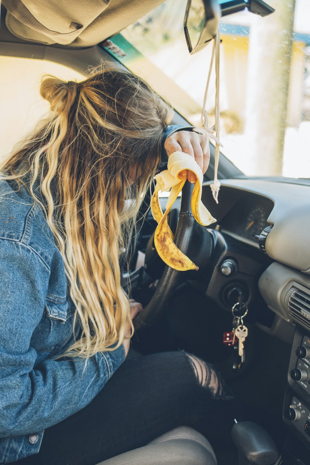 woman in blue denim jacket driving car