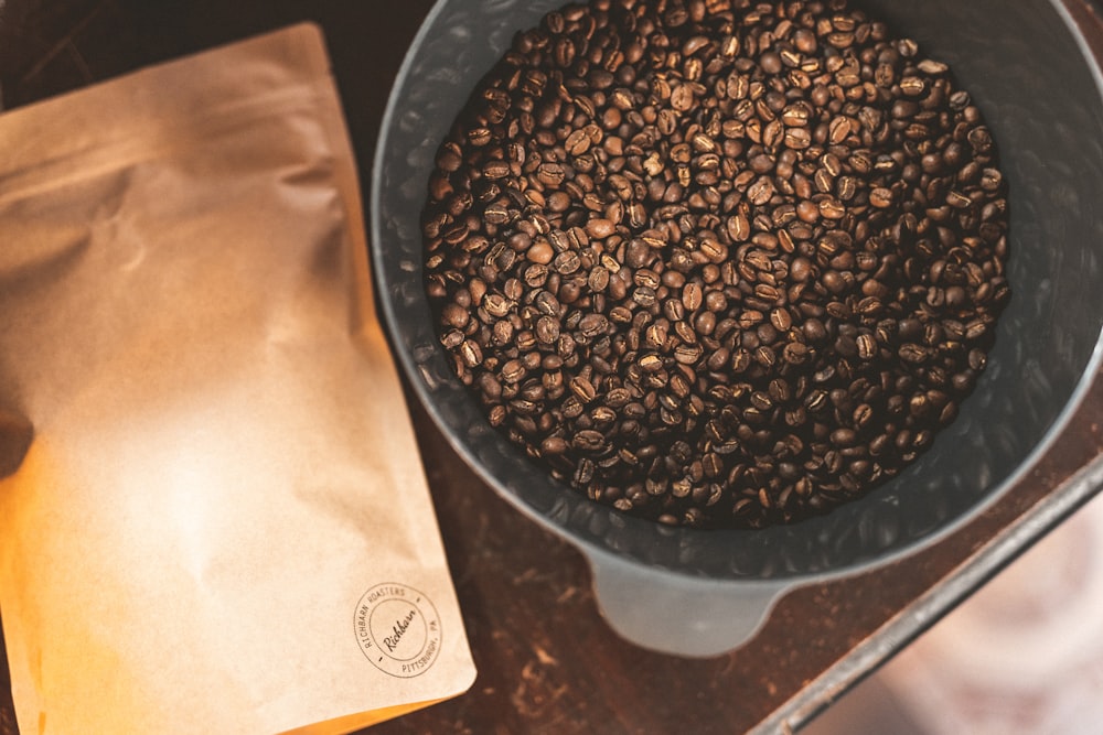 ステンレス製のボウルに黒と茶色のコーヒー豆