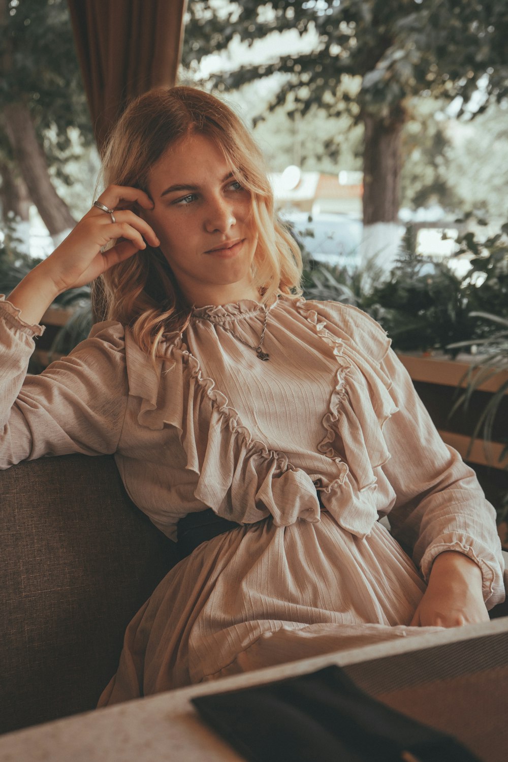 woman in brown long sleeve dress sitting on brown couch