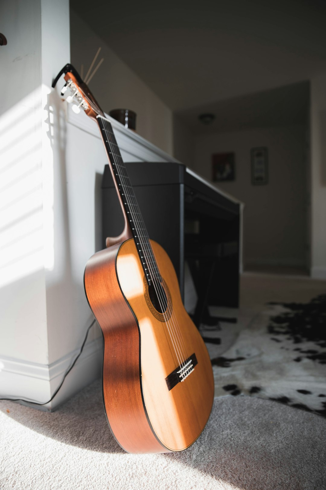 brown acoustic guitar on black stand