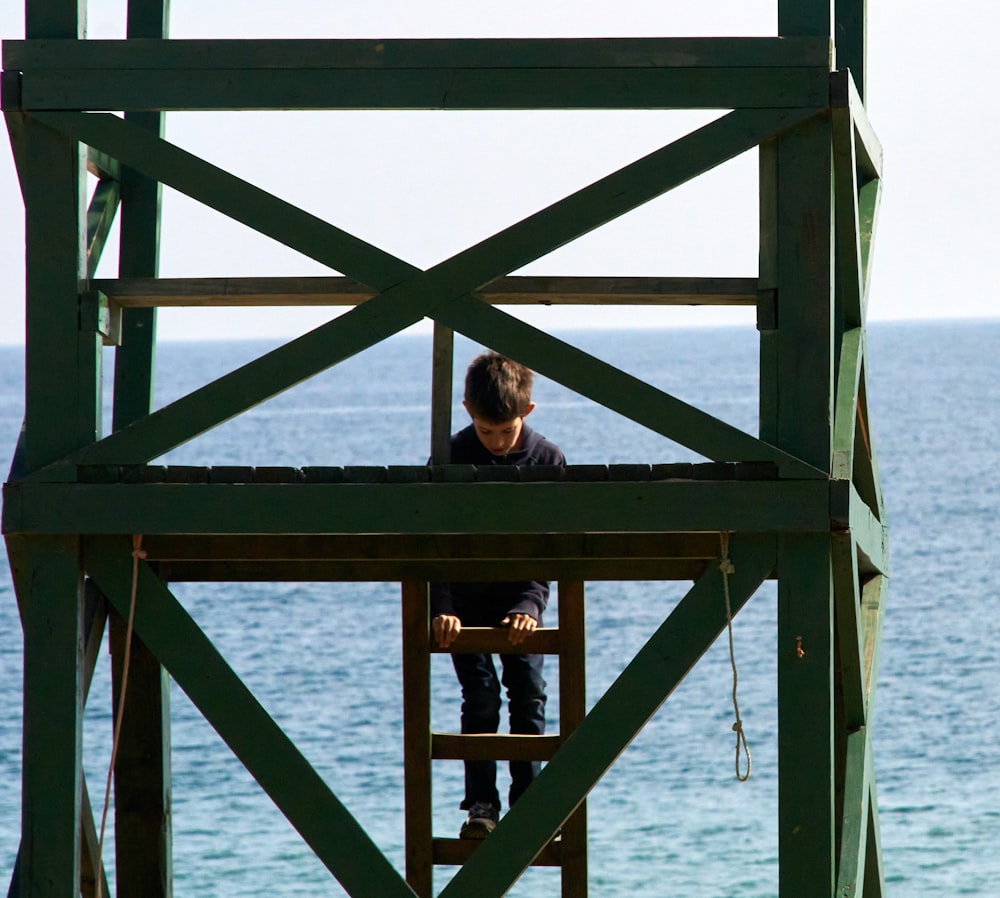 woman in black shirt standing on brown wooden dock during daytime