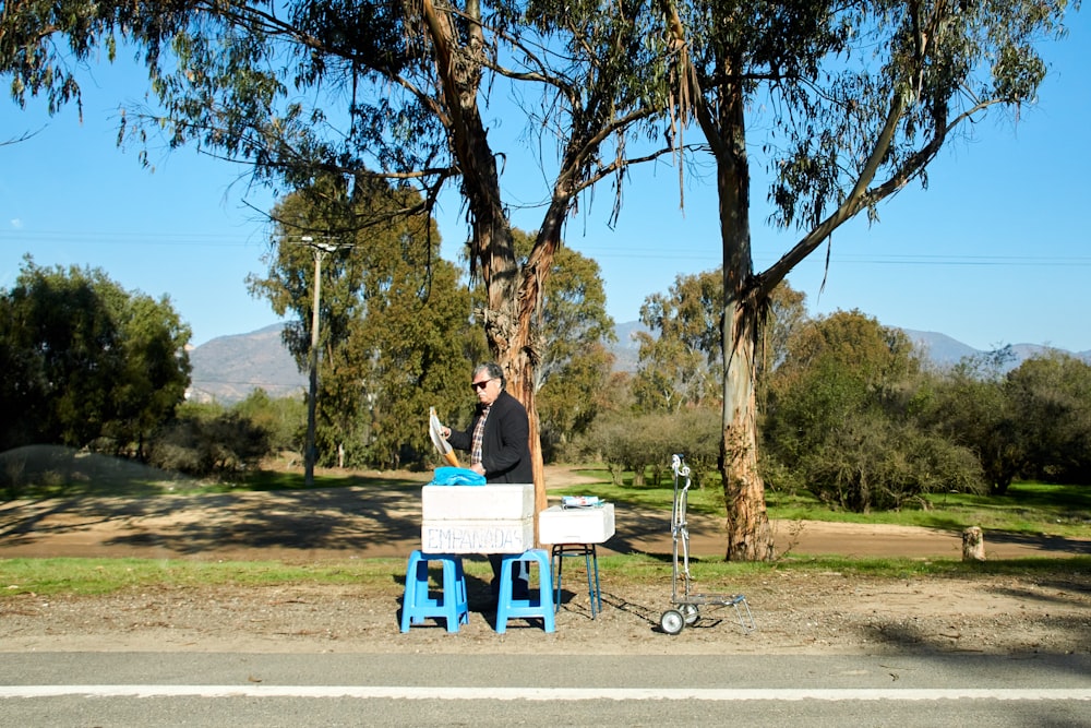 woman in black shirt sitting on white bench during daytime