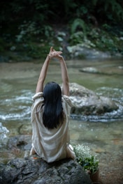 woman in white shirt standing on river during daytime