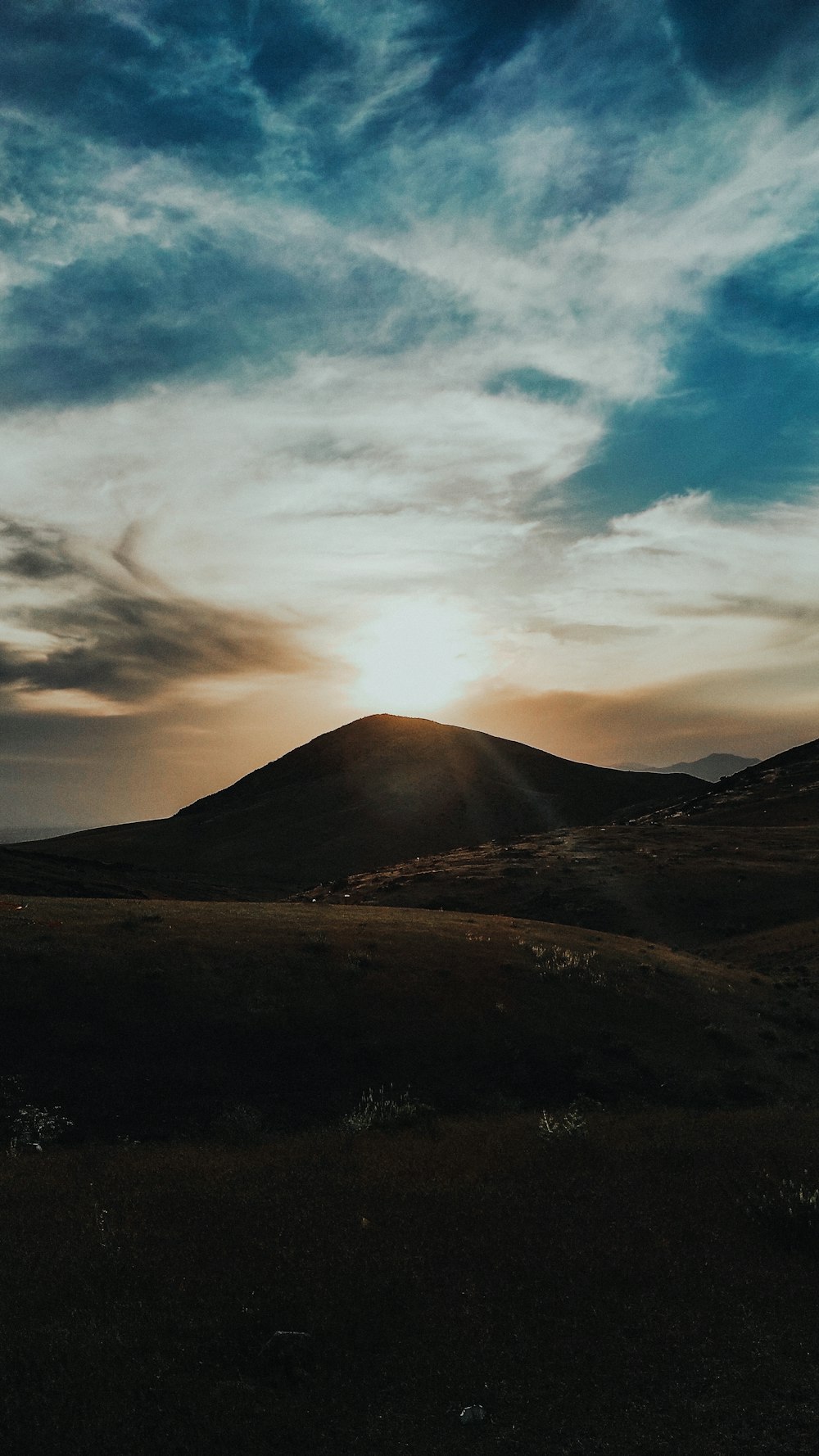 brown mountain under white clouds during daytime