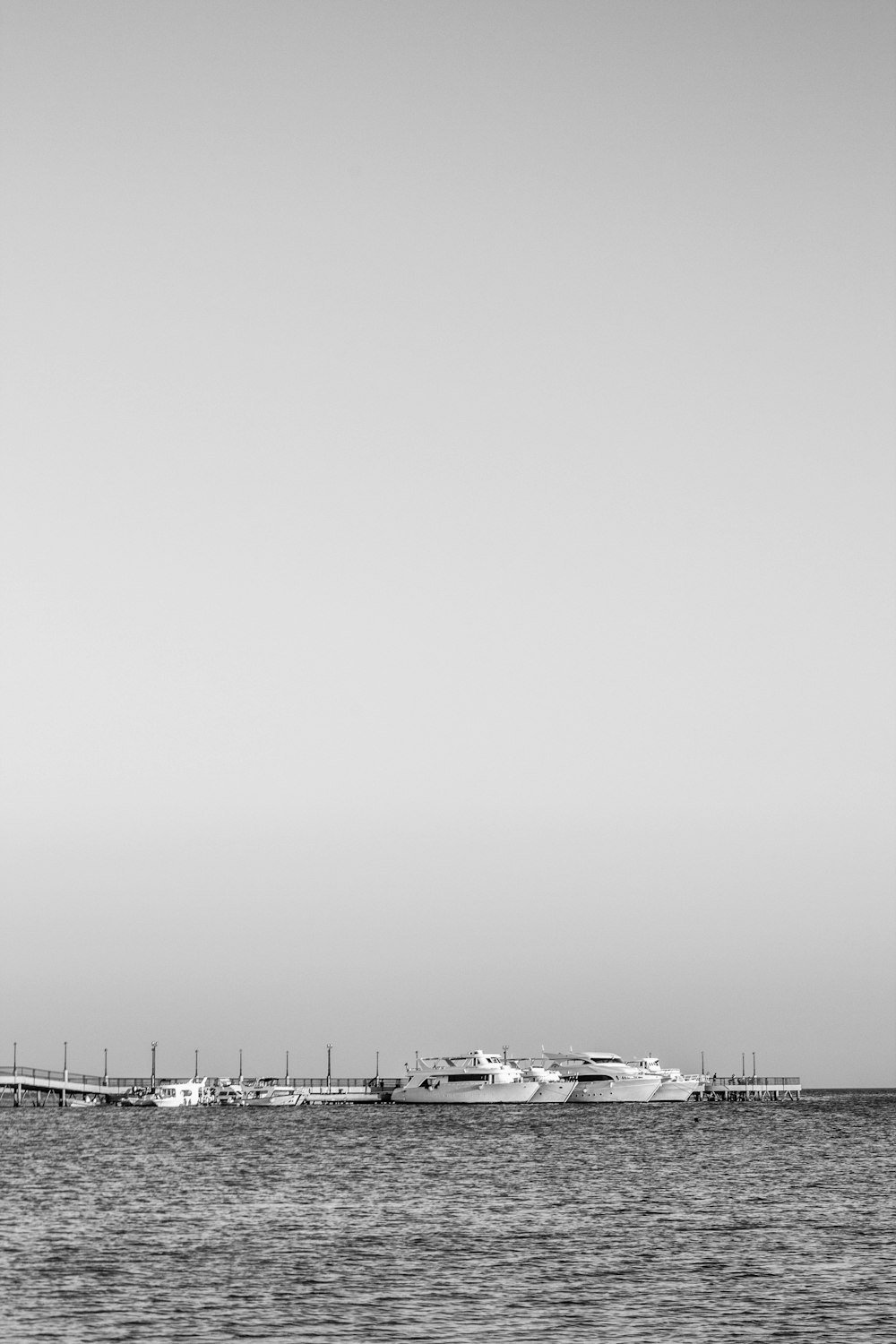 grayscale photo of a beach with a view of a city