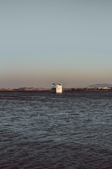 white lighthouse near body of water during daytime