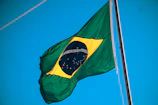 The official flag of Bahia waving gently against a clear blue sky.