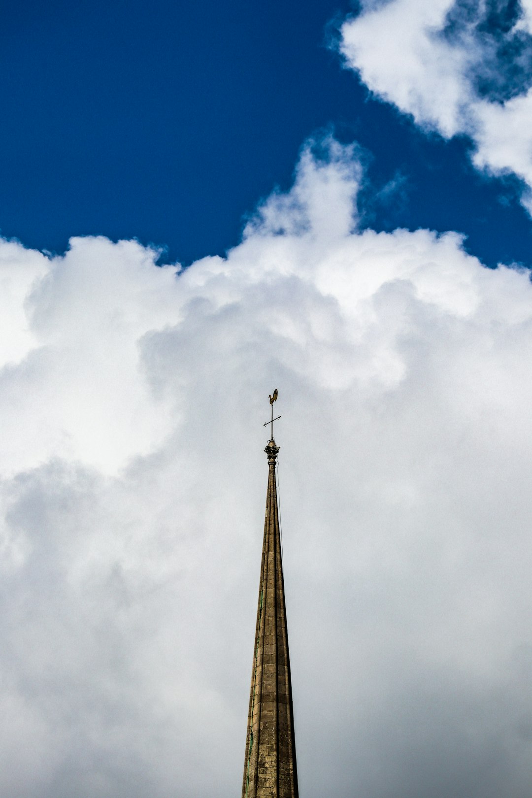 brown tower under blue sky and white clouds during daytime