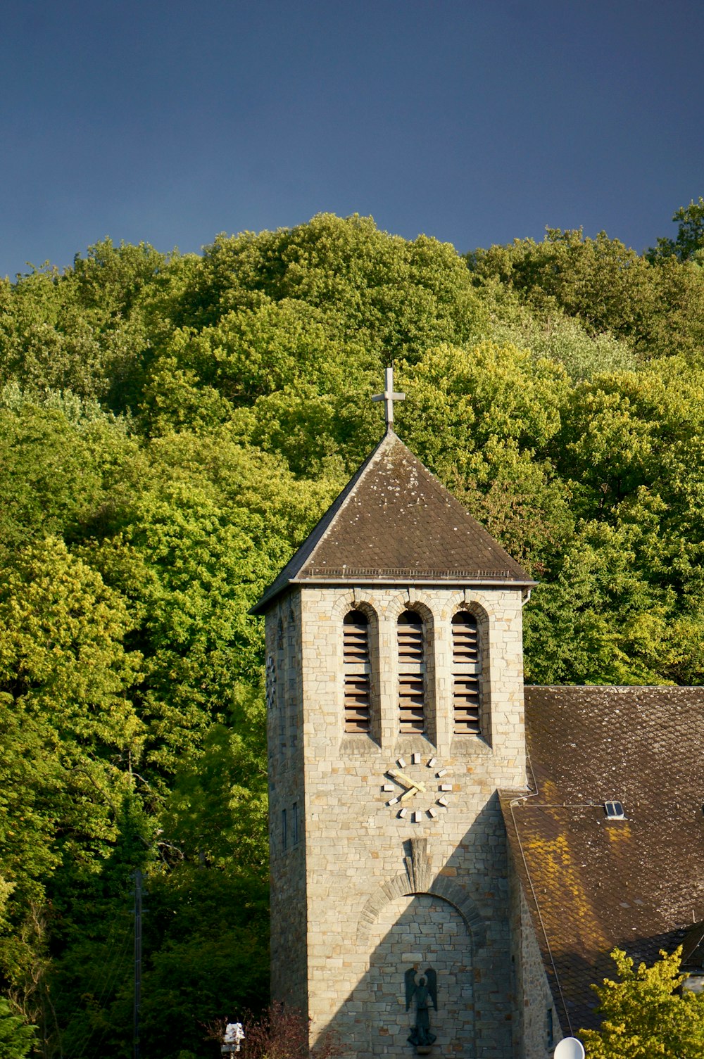 brown concrete church surrounded by green trees during daytime