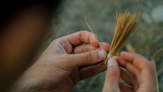 Close-up of hands packaging handcrafted snack bags with natural kraft paper and twine in a cozy workshop.