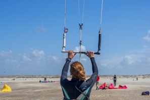 woman in black jacket and blue denim jeans sitting on swing during daytime