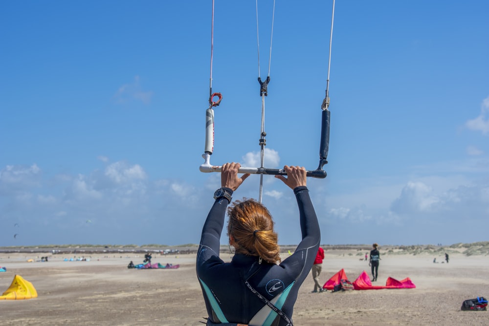 woman in black jacket and blue denim jeans sitting on swing during daytime