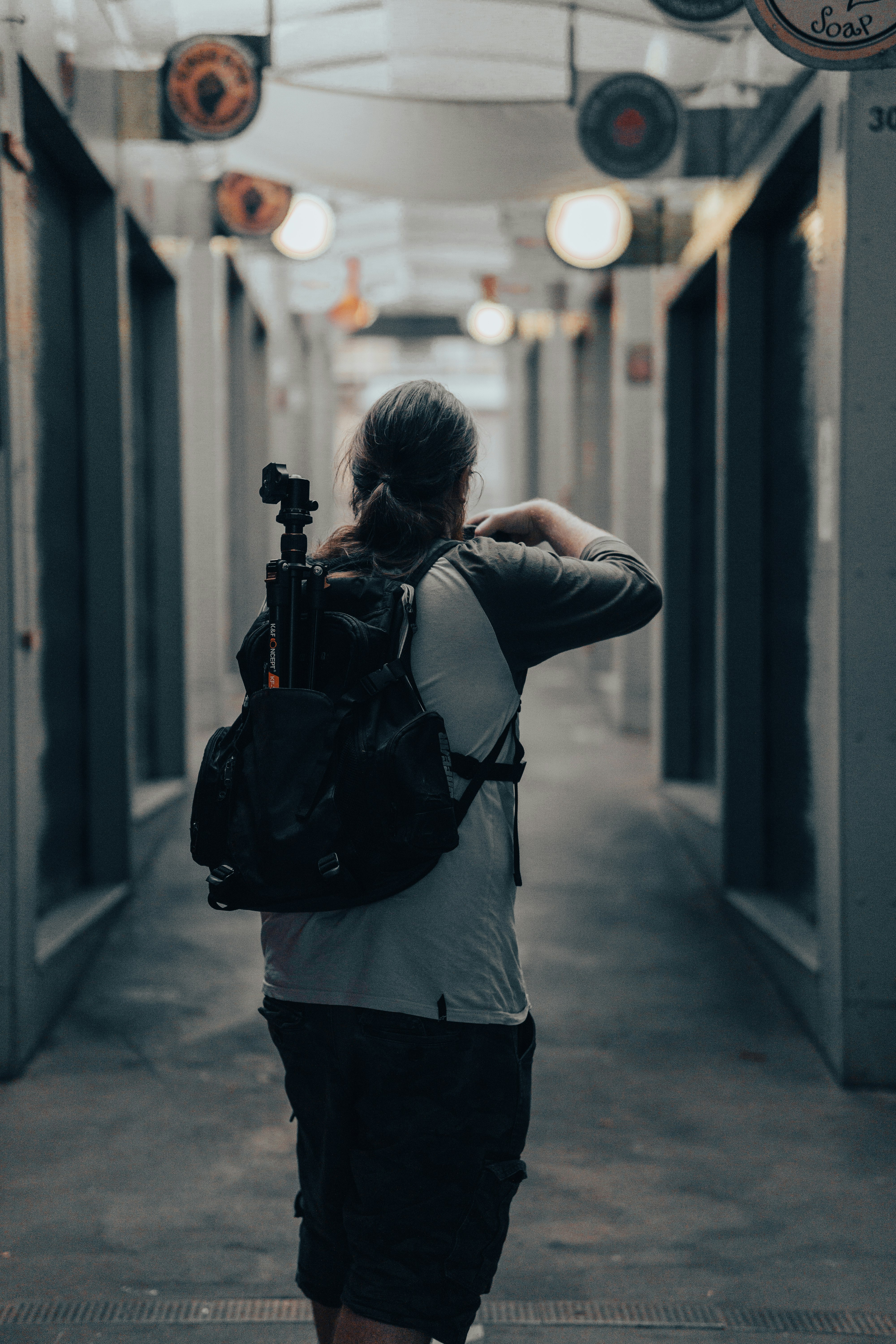 woman in gray long sleeve shirt and black pants carrying black backpack