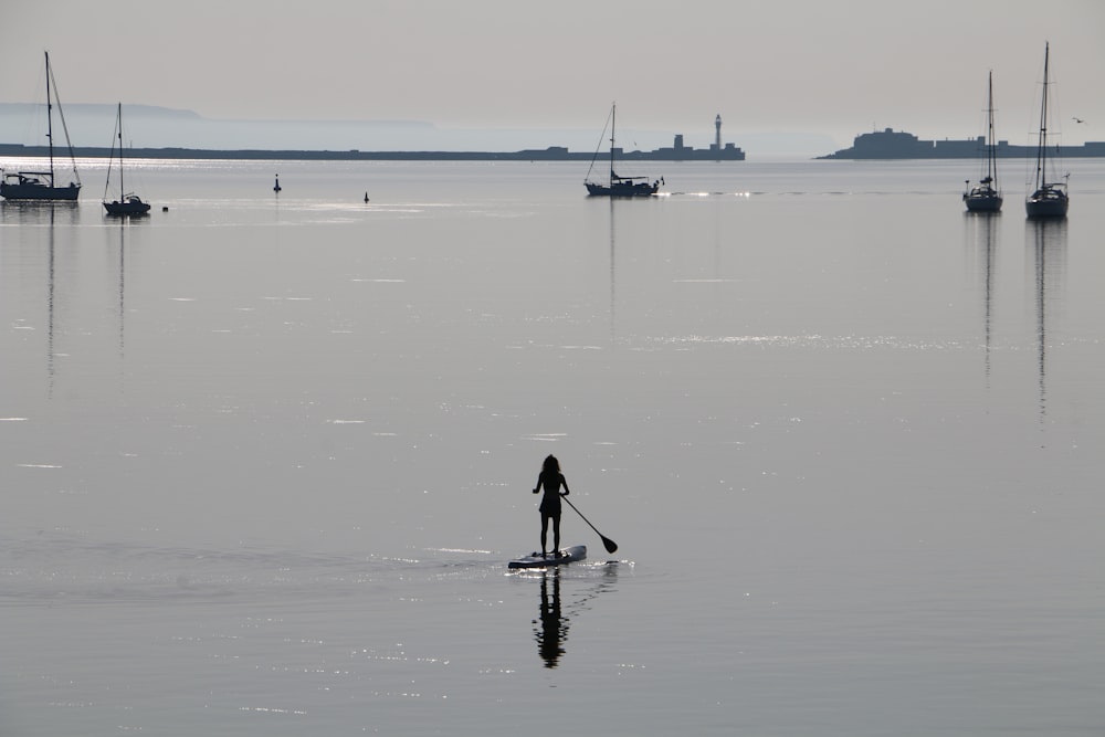 person in black shirt and pants standing on sea shore during daytime