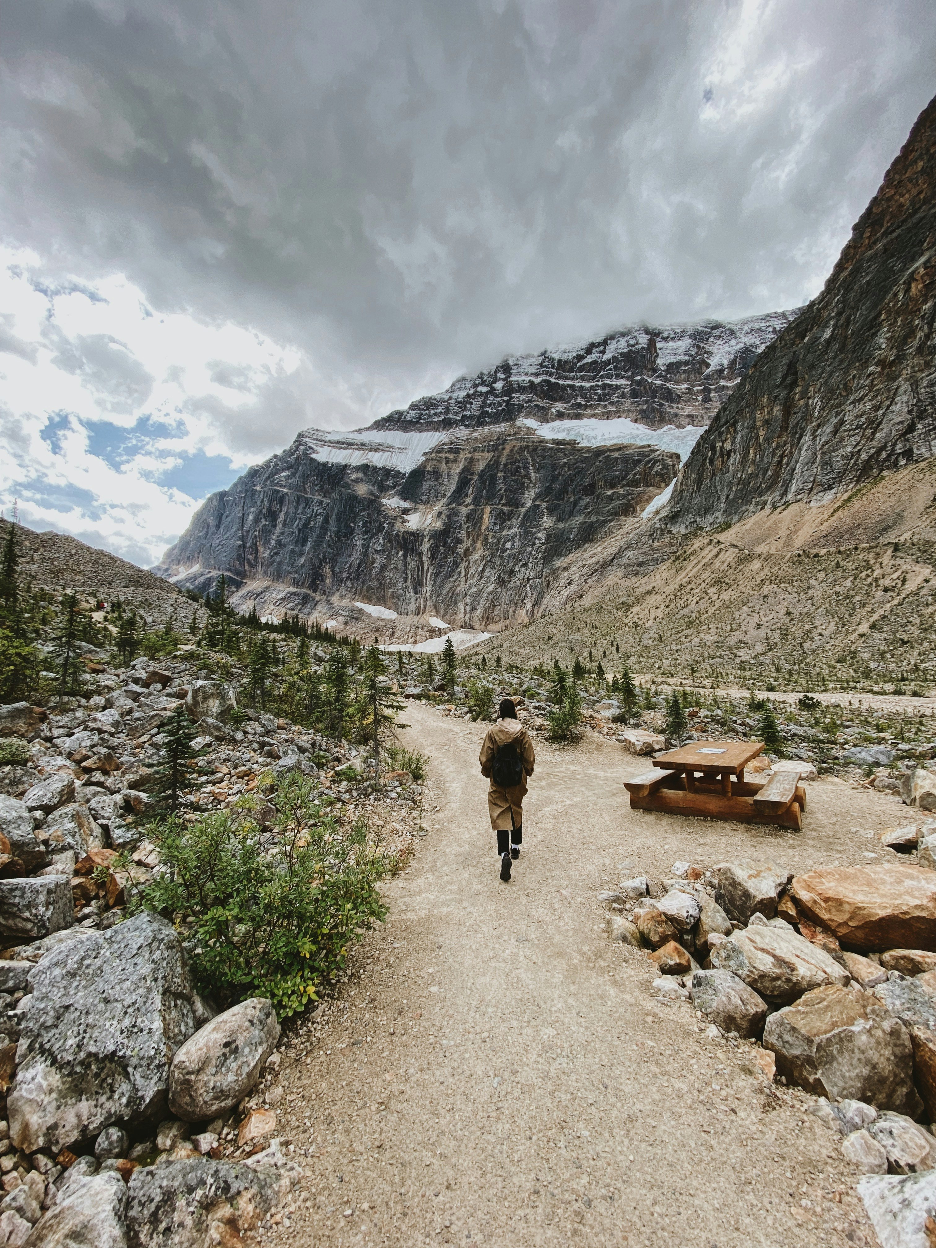 2 people walking on pathway near mountains during daytime