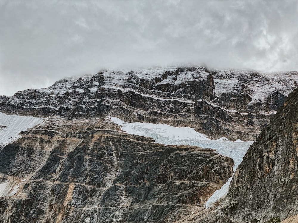 snow covered mountain under cloudy sky during daytime