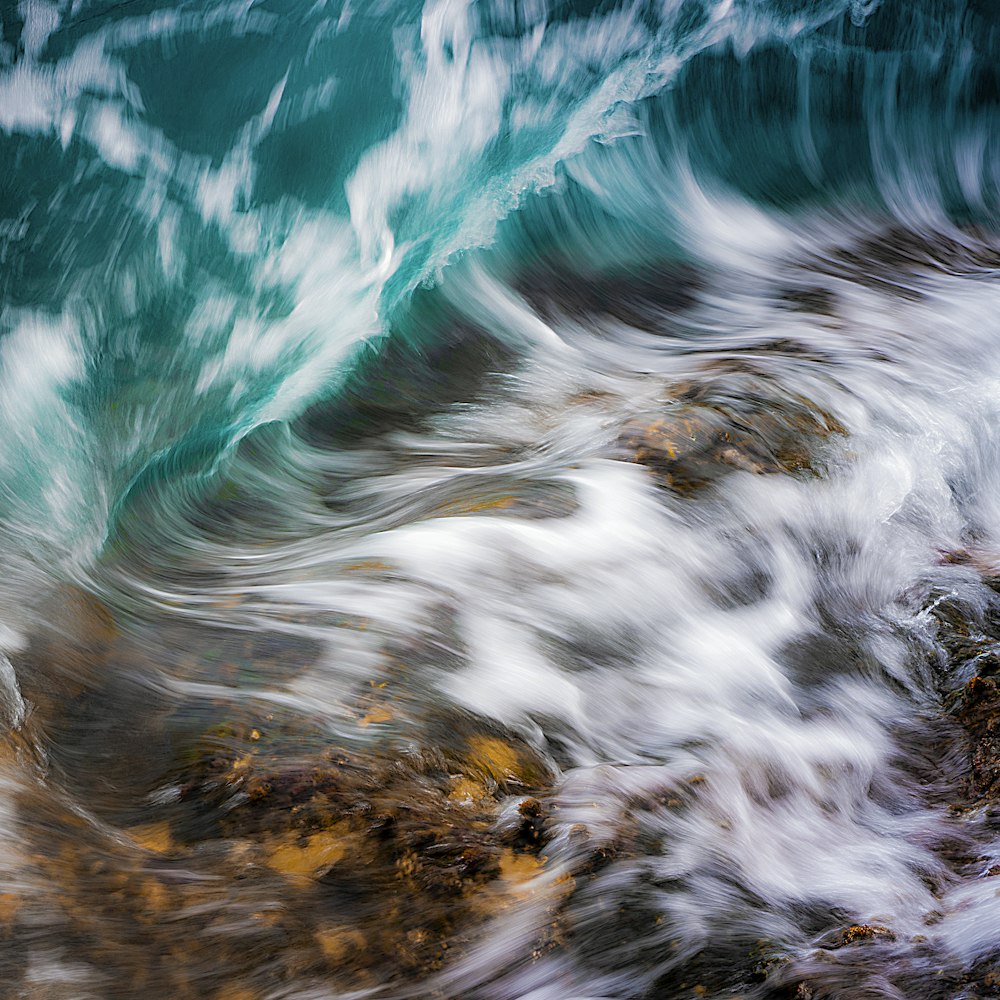 ondas de água batendo em rochas durante o dia