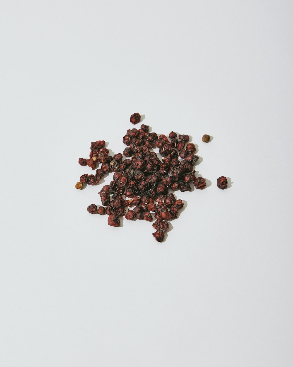 a pile of raisins sitting on top of a white table