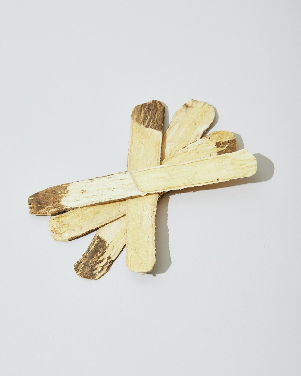 uma cruz feita da madeira em um fundo branco