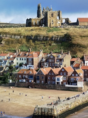 people walking on beach near brown concrete building during daytime