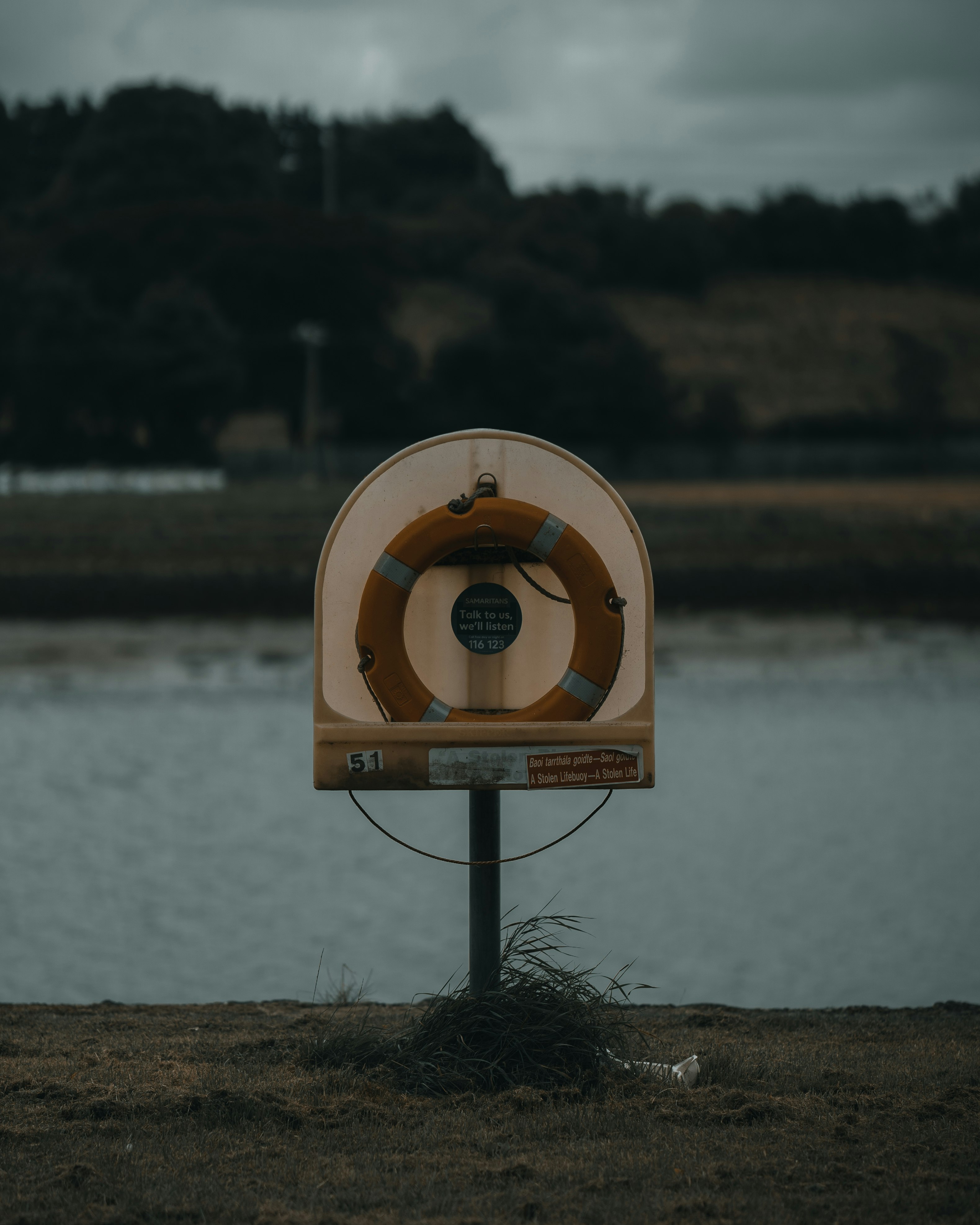 brown and white metal stand near lake during daytime