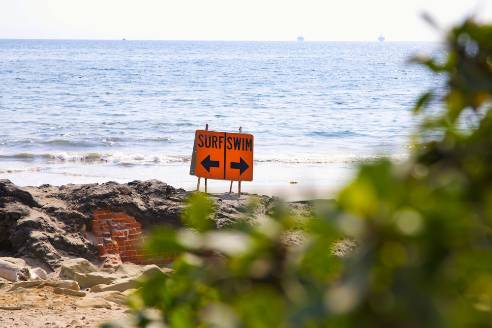 yellow and black no smoking sign near sea during daytime