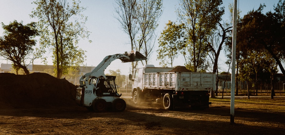 white and black utility truck on brown field during daytime