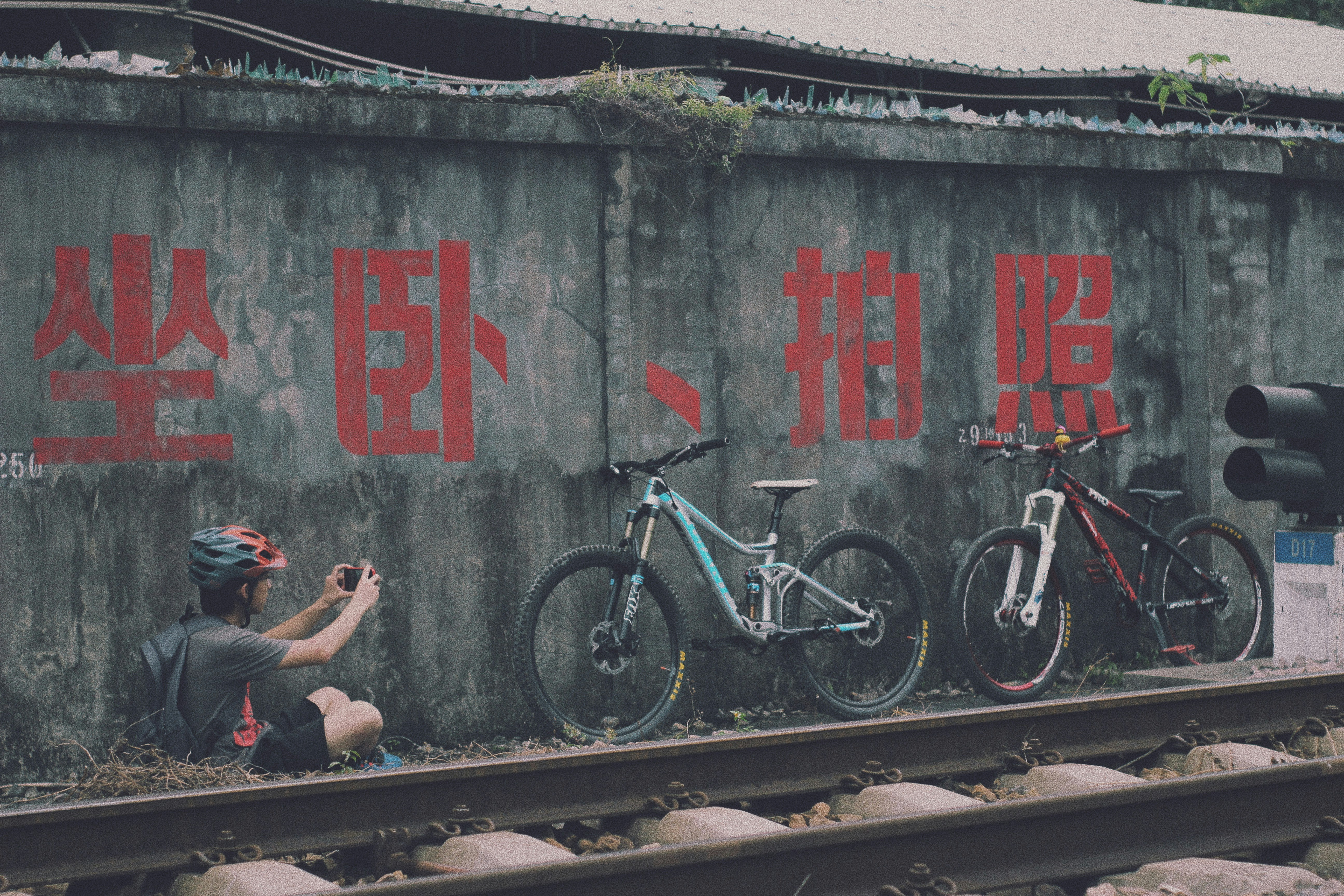 man in black t-shirt and black shorts sitting on brown wooden bench