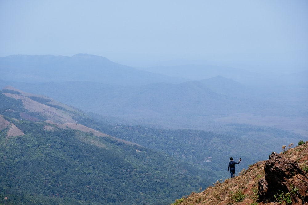 person standing on rock mountain during daytime