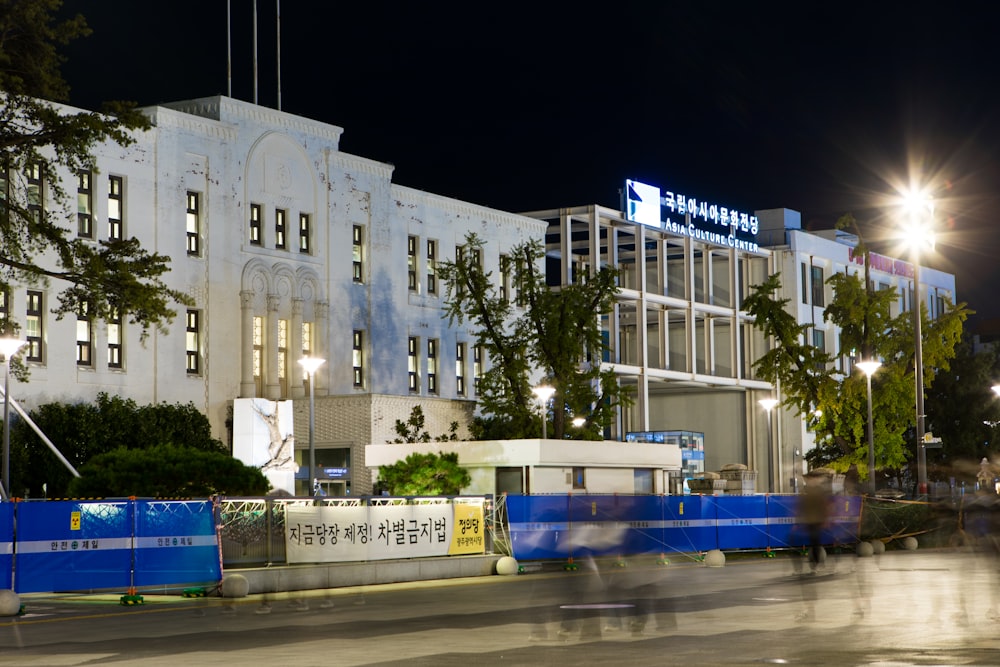 white and blue bus near white concrete building during night time