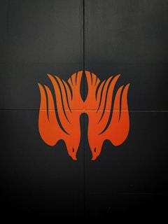 An abstract graphic piece with orange accents against a dark background.