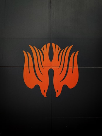 An abstract graphic piece with orange accents against a dark background.