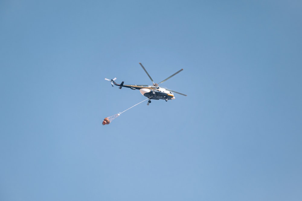 white and black helicopter in mid air