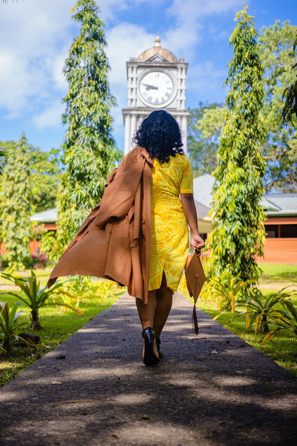 Mujer con abrigo amarillo caminando por la calle durante el día