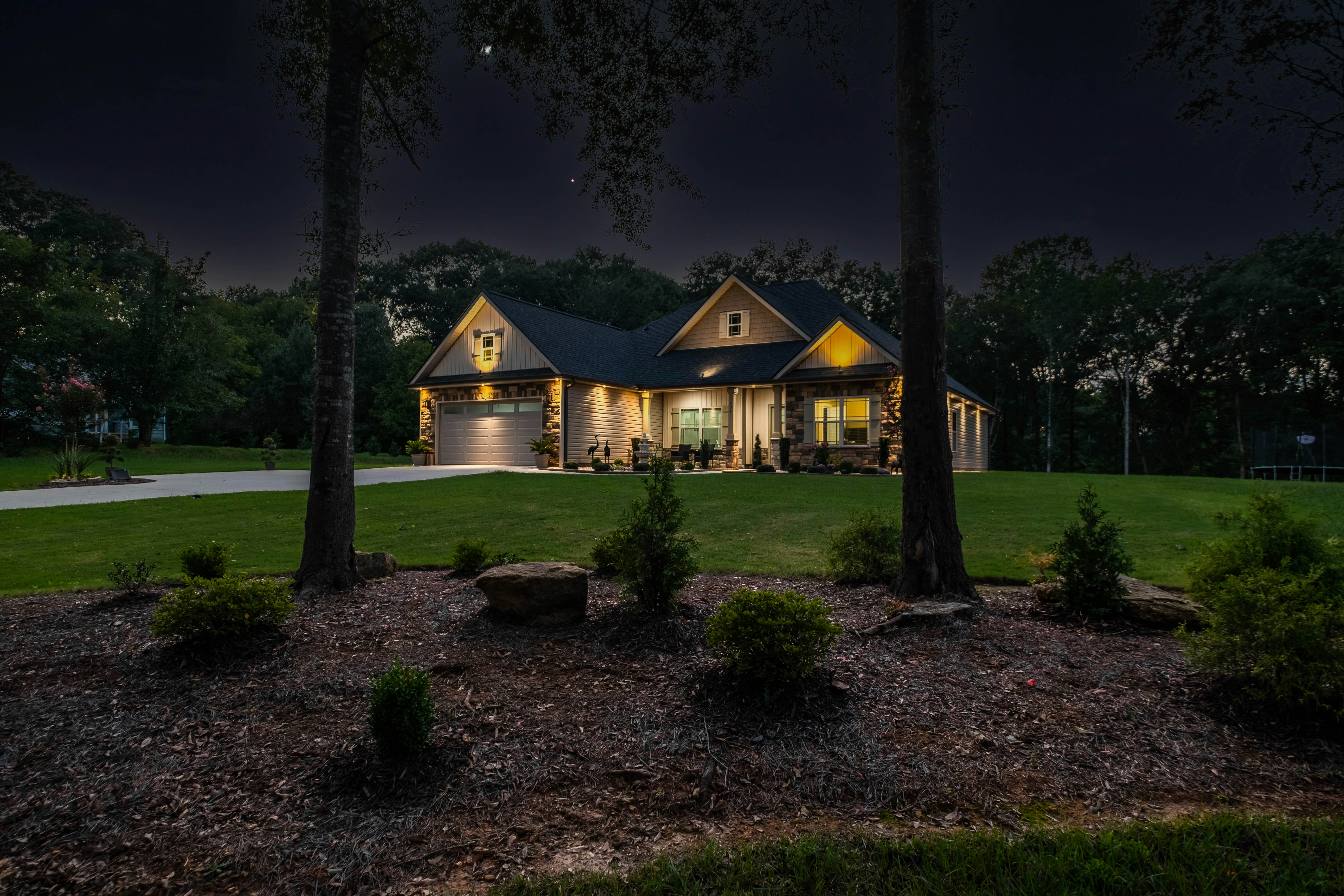 brown wooden house surrounded by trees during nighttime