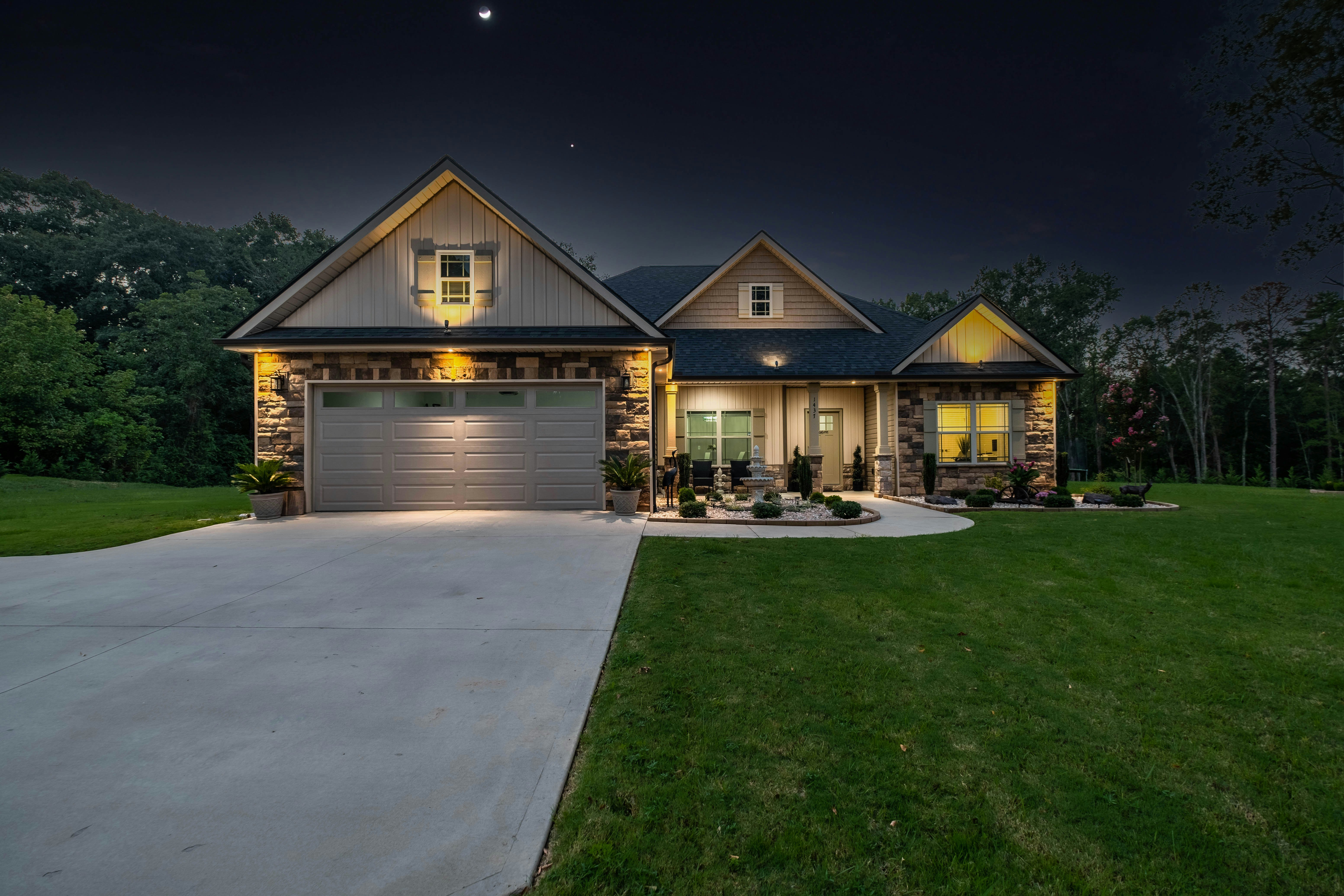 brown wooden house near green grass field during night time