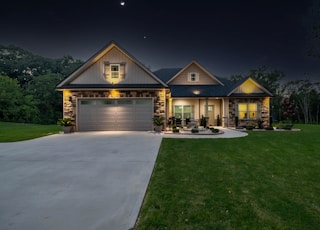 brown wooden house near green grass field during night time