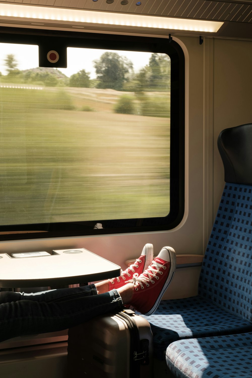 person in red and white sneakers sitting on blue and white chair