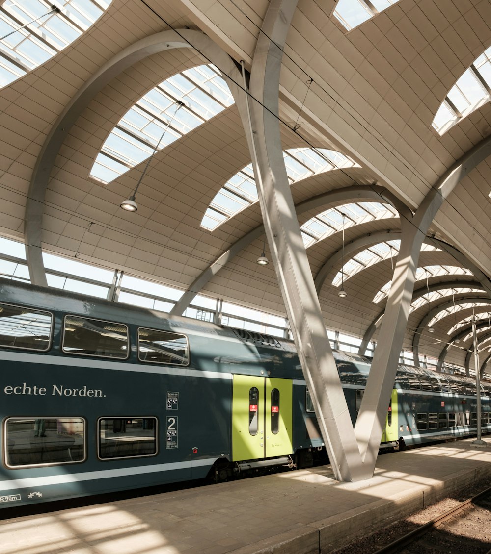 green and white train in train station