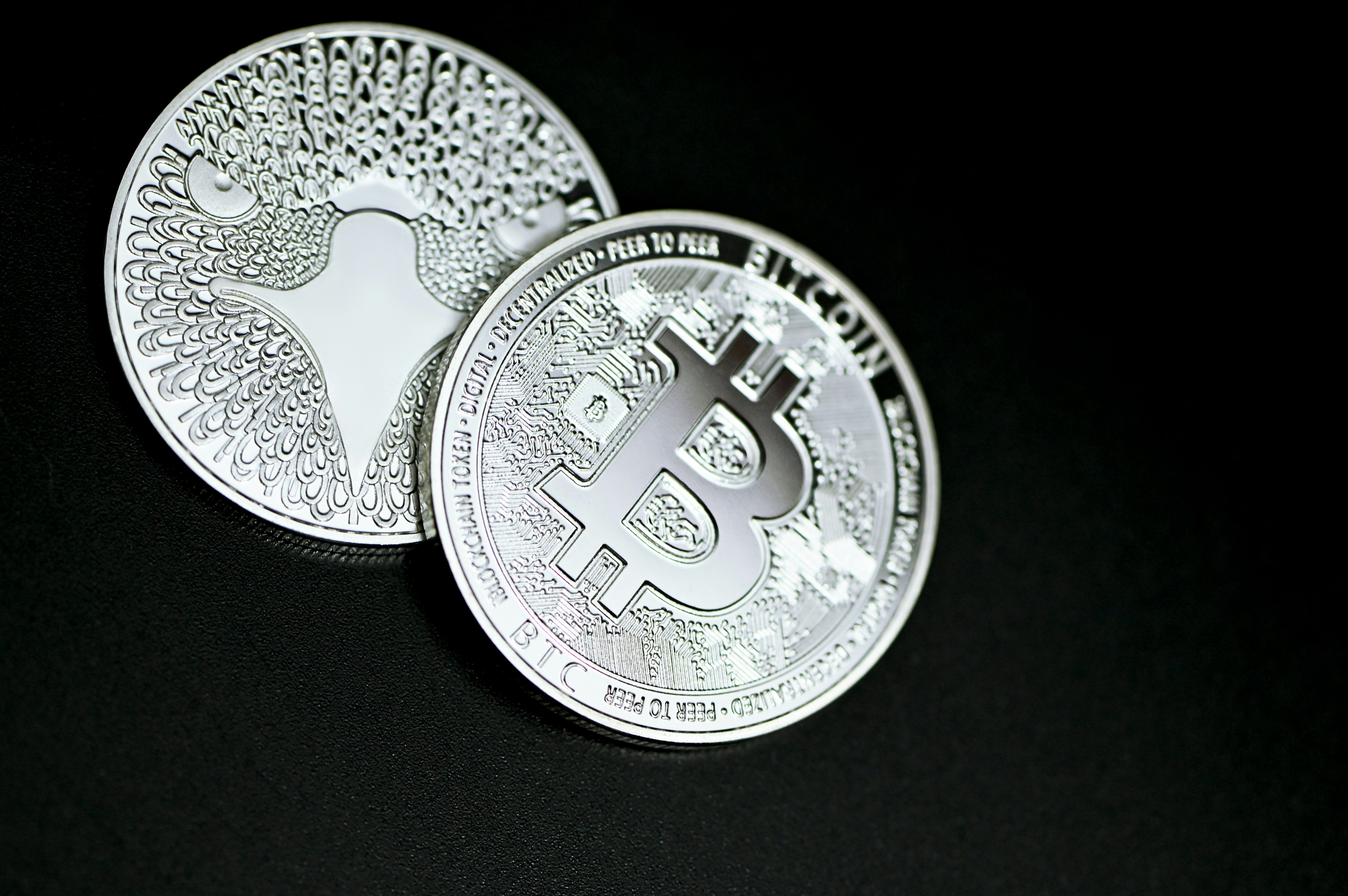 silver round coin on black textile